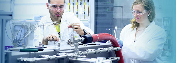 Two researchers (male and female) working at set-up of the LOHC-dehydrogenation unit (Image: EAM/Minx)