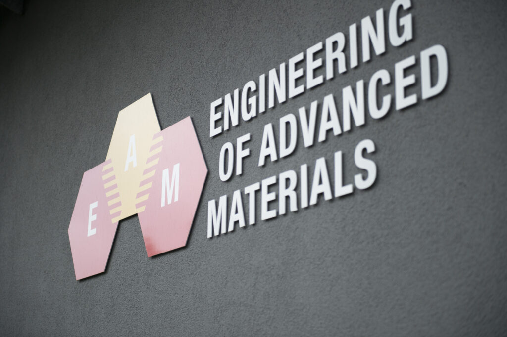 Logo of Cluster of Excellence Engineering of Advanced Materials (Red and yellow hexagons with letters "EAM") on one of the new constructed research buldings